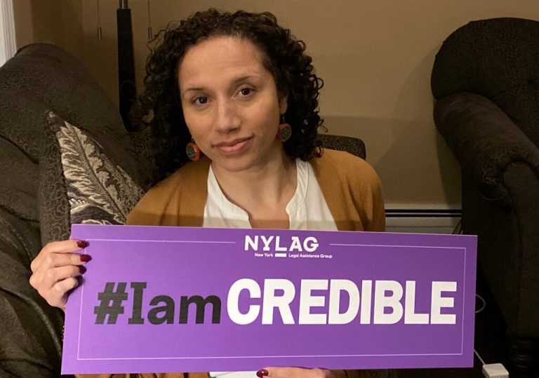 Natalie Gutierrez holds a purple sign that reads "#IamCredible"