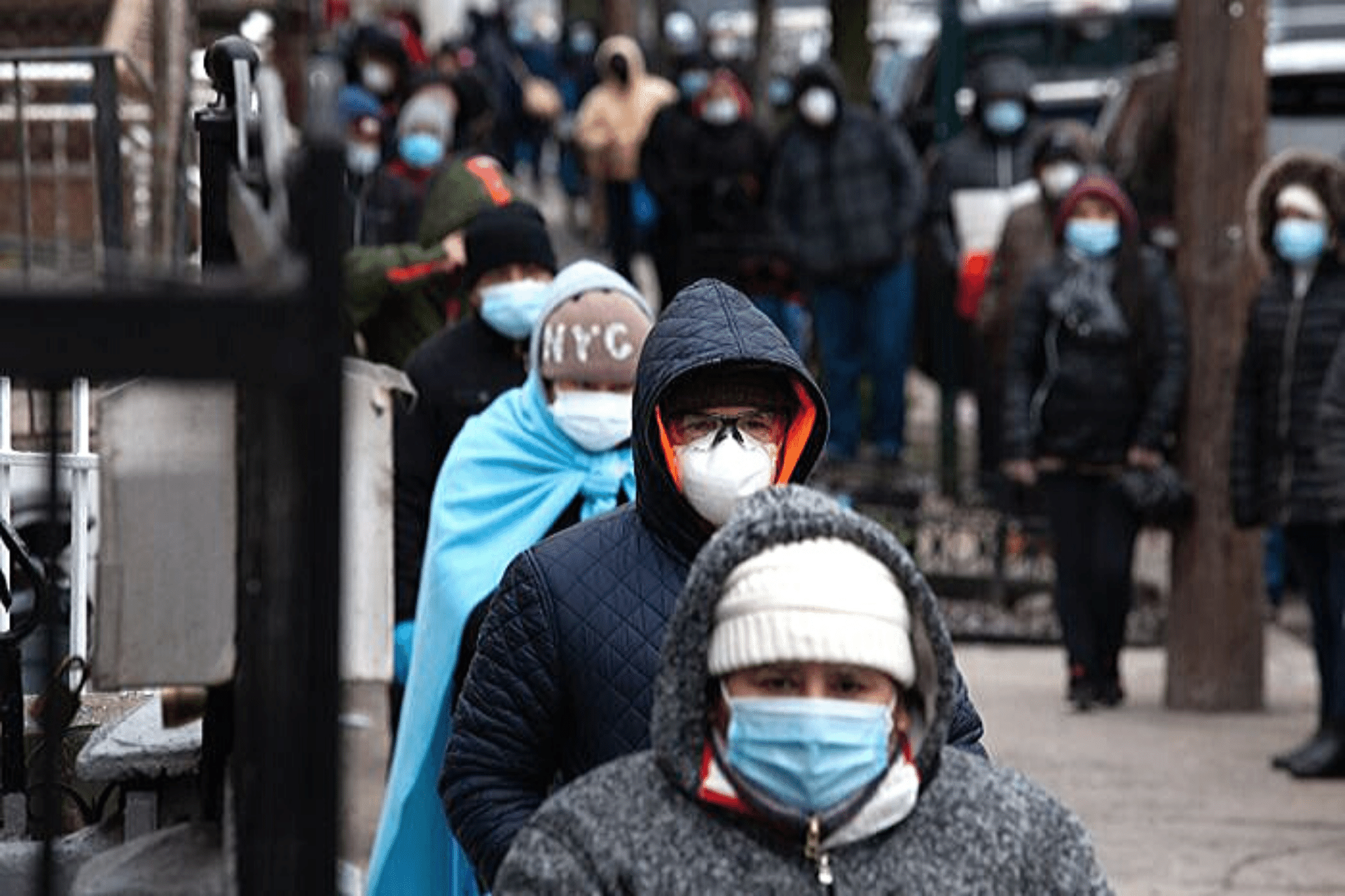 A long line of people wearing face masks