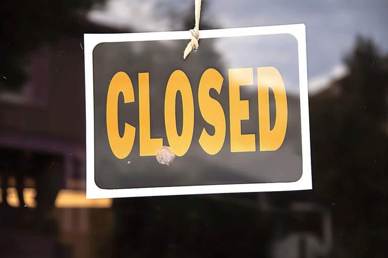 A "closed" sign hanged on a window.