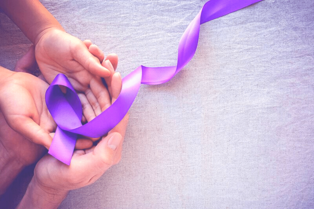Hands holding a purple ribbon.