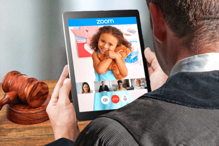 Image of a man holding up a tablet picturing a young girl squeezing a teddy bear.