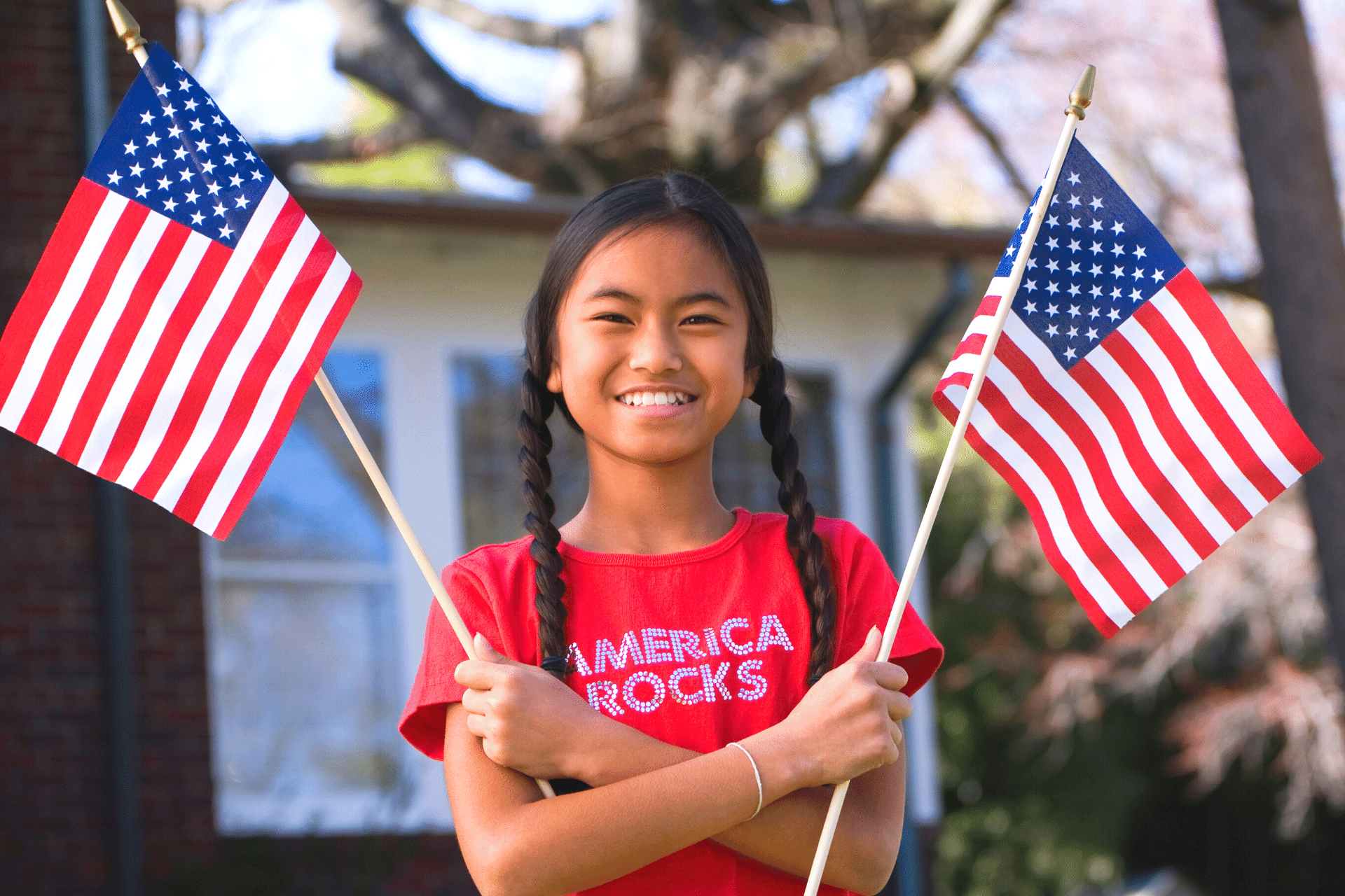 Girl holding two American flags.