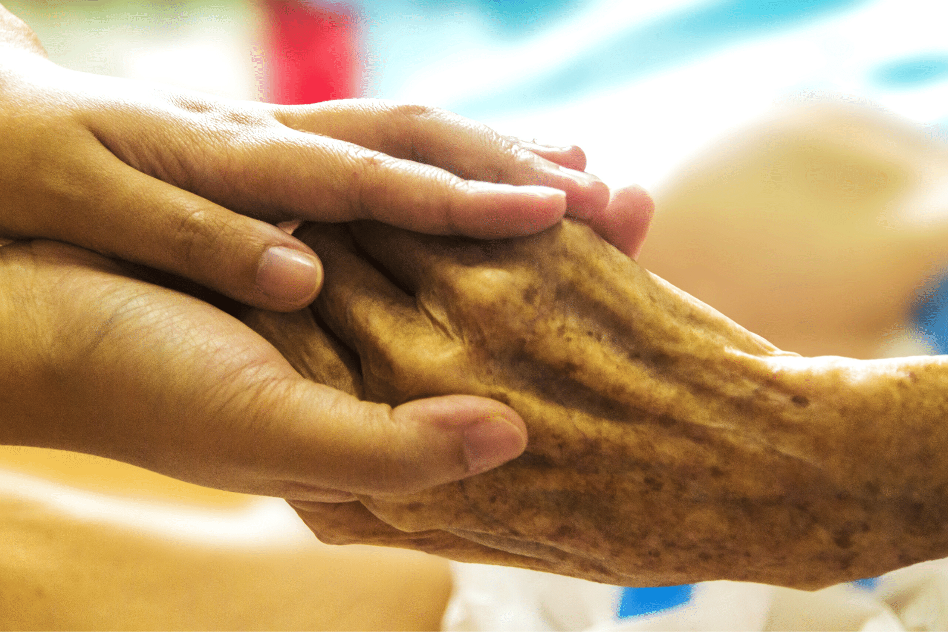 Holding an elder person's hand with care