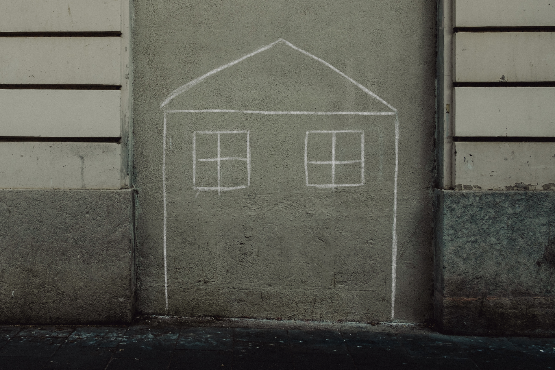 Chalk drawing of house on a concrete wall
