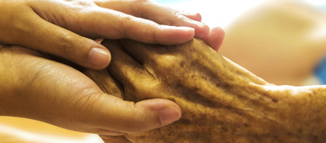 Holding an elder person's hand with care