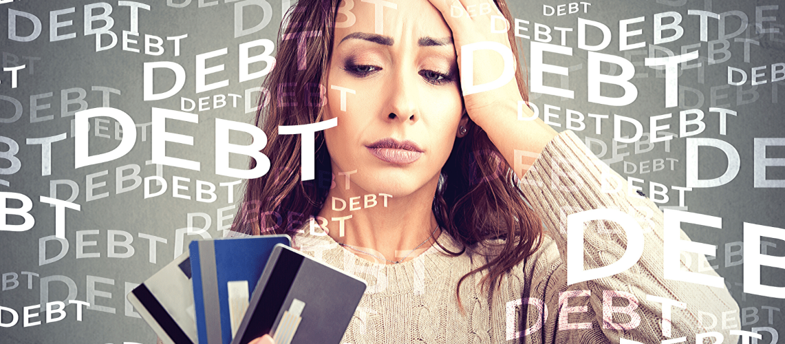 An image of a woman holding several credit cards in her hand. She looks stressed out. The words, "debt" floats around her.