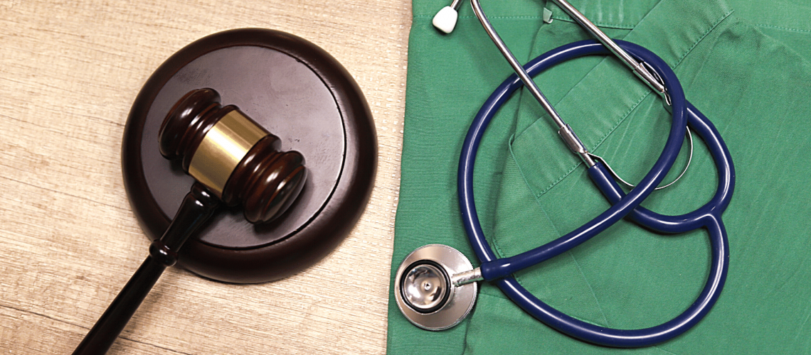 Medical law, medical law concept, gavel, green scrub, and stethoscope
